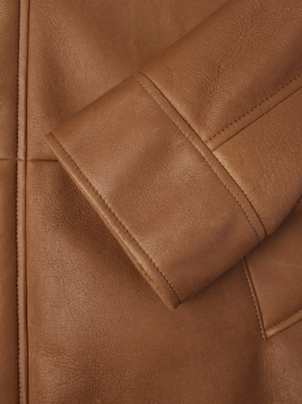 Close-up of brown leather jacket with visible stitching