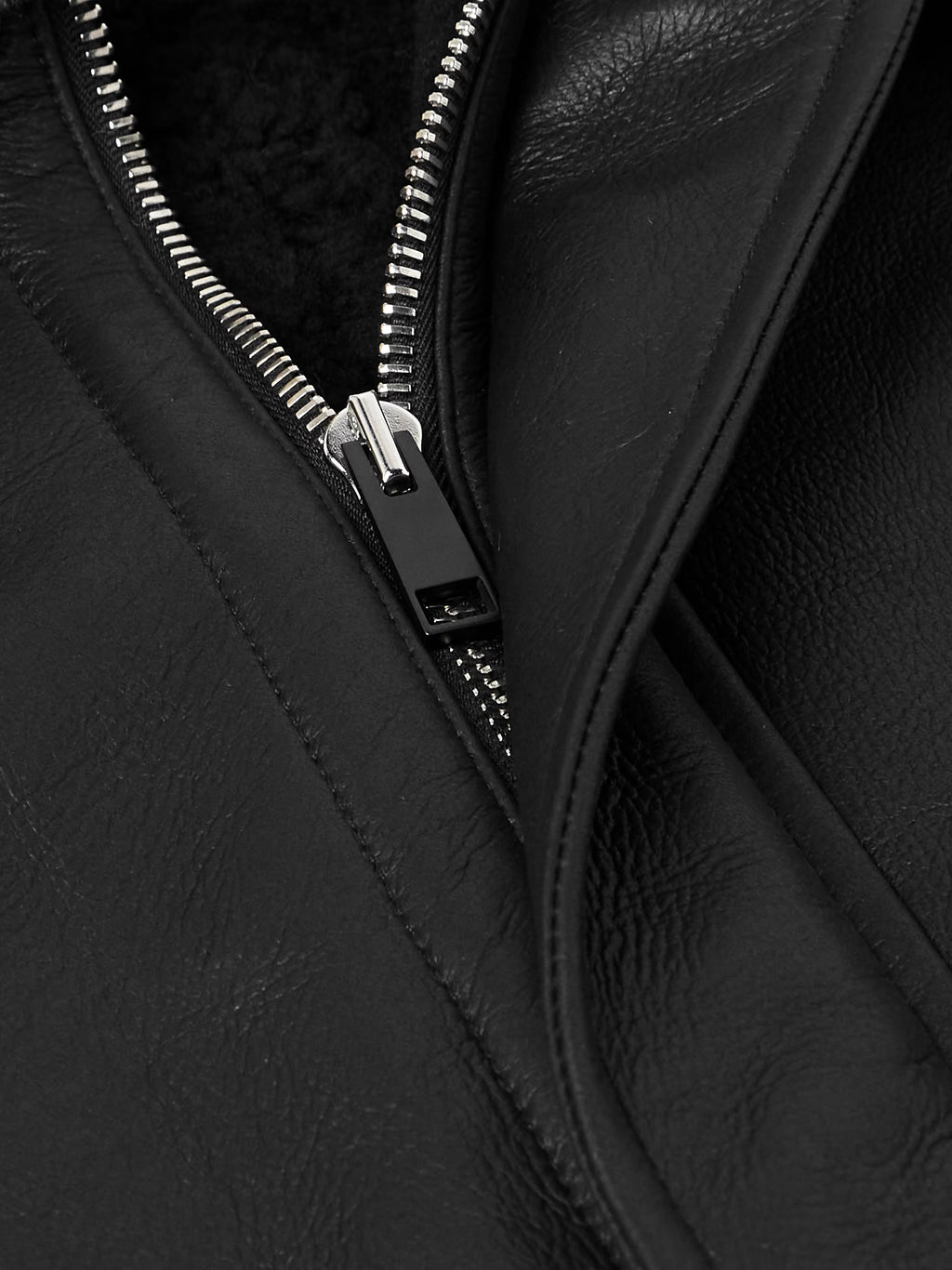Close-up of a black leather jacket with a zipper