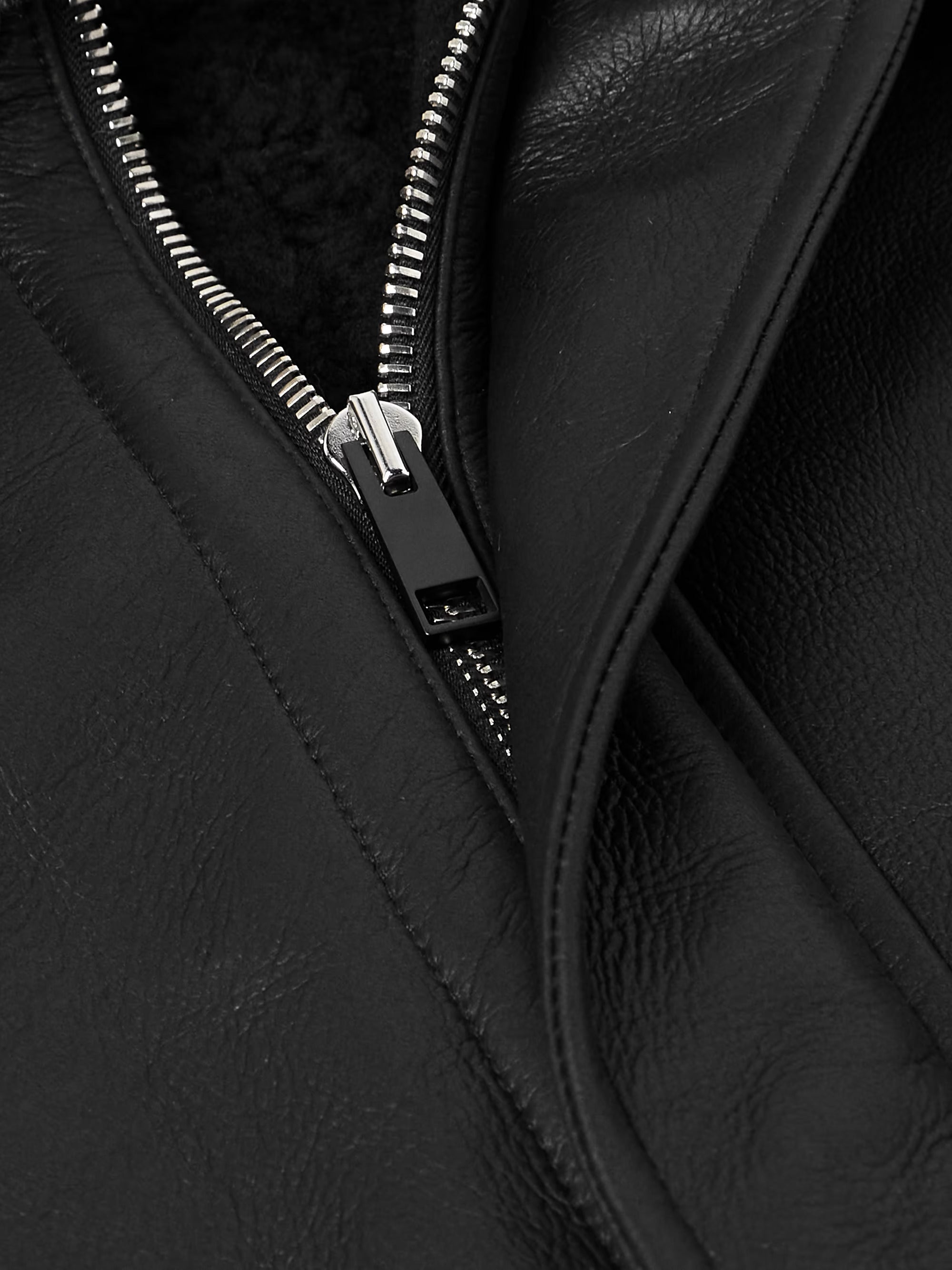 Close-up of a black leather jacket with a zipper