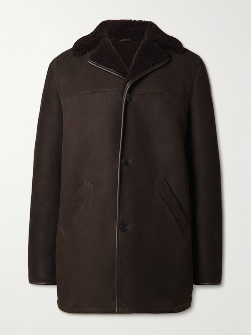 Men’s brown suede leather  coat with shearling collar, button-front closure, and angled side pockets on a light background.